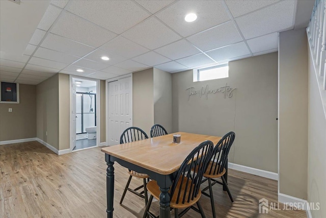 dining space with wood finished floors, baseboards, a paneled ceiling, and recessed lighting