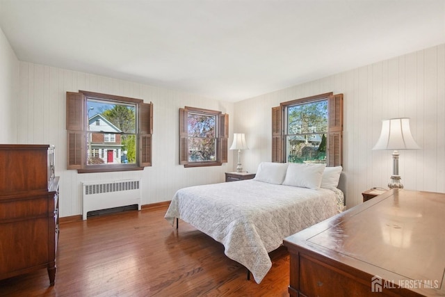 bedroom with radiator and wood finished floors