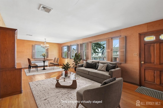 living room featuring a chandelier and light wood-style flooring