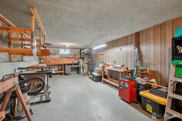 basement with a workshop area and wooden walls