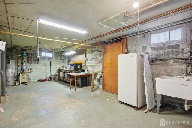 basement featuring gas water heater, a workshop area, and a sink
