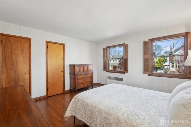 bedroom featuring wood finished floors and radiator heating unit