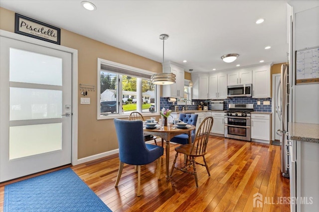 dining space with light wood-style floors and recessed lighting