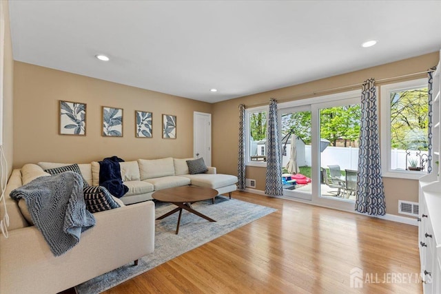living area featuring light wood-style flooring, recessed lighting, and baseboards