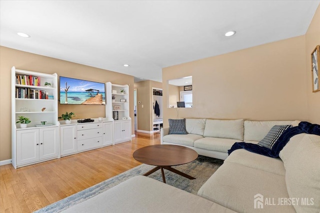 living area with light wood-style flooring, baseboards, and recessed lighting