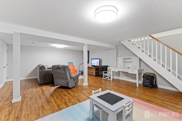 living room with stairway, wood finished floors, and baseboards