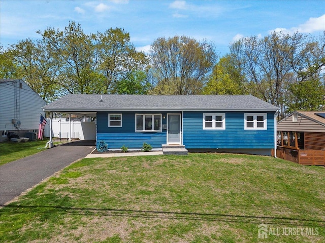 ranch-style home featuring a front lawn, asphalt driveway, entry steps, and an attached carport