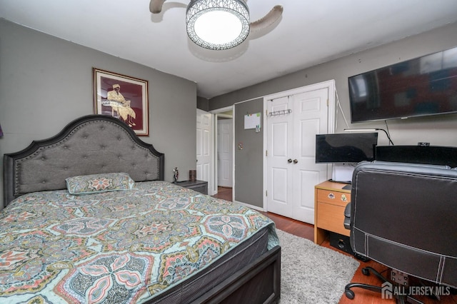 bedroom with ceiling fan, a closet, and wood finished floors