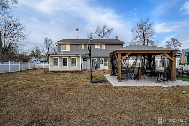 rear view of house featuring a yard, a fenced backyard, a patio, and a gazebo