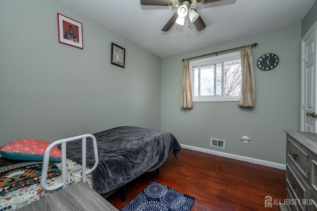 bedroom with ceiling fan, dark wood-type flooring, visible vents, and baseboards