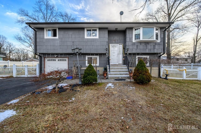 split foyer home with an attached garage and fence