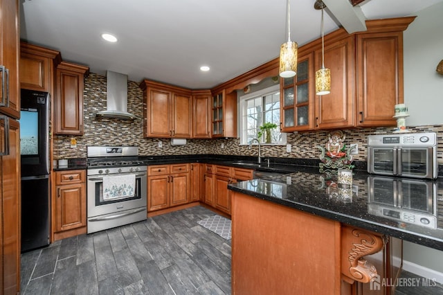 kitchen featuring wall chimney range hood, brown cabinets, and stainless steel range with gas stovetop