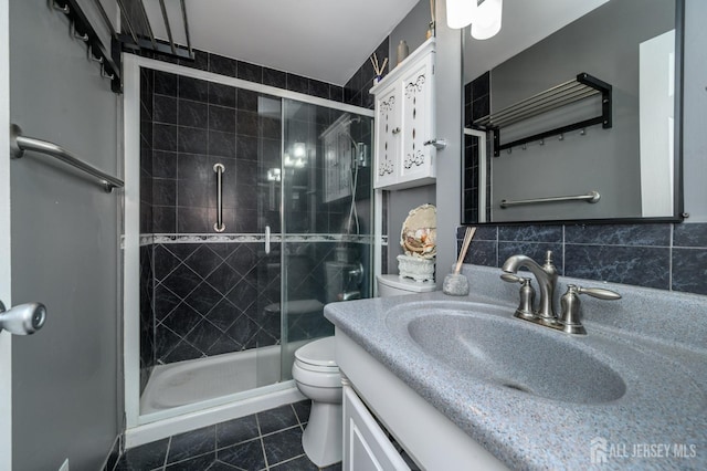 full bathroom with a stall shower, tile patterned flooring, vanity, and toilet