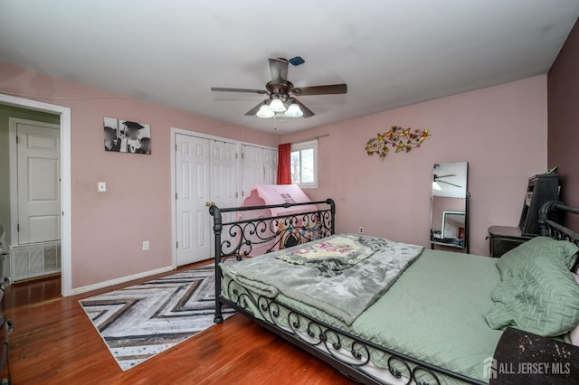 bedroom featuring ceiling fan, baseboards, and wood finished floors