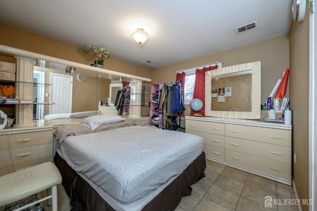 bedroom with light tile patterned floors and visible vents