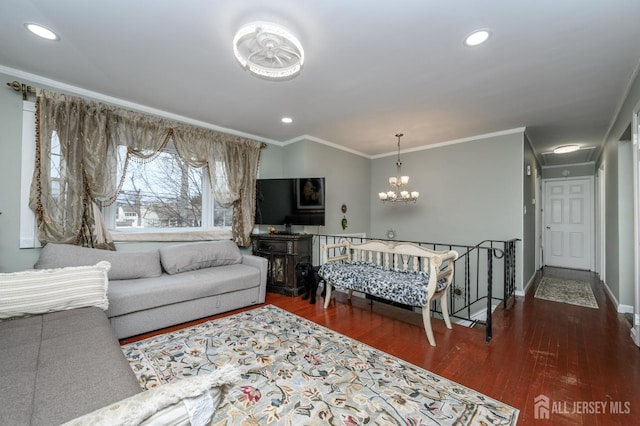 living room featuring a chandelier, ornamental molding, and wood finished floors