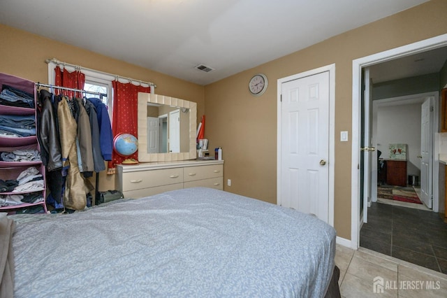 tiled bedroom featuring baseboards and visible vents