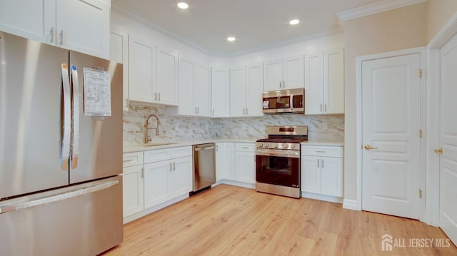 kitchen with decorative backsplash, sink, white cabinets, and stainless steel appliances