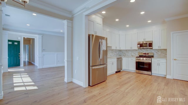 kitchen featuring crown molding, decorative backsplash, light wood-type flooring, appliances with stainless steel finishes, and white cabinetry