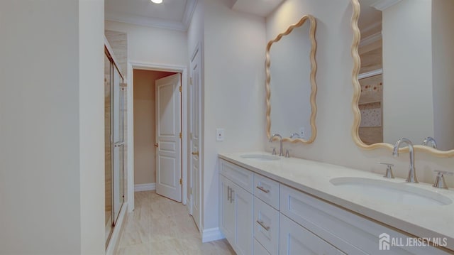 bathroom with crown molding, a shower with door, and vanity