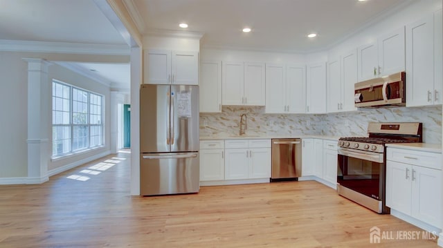 kitchen featuring crown molding, sink, white cabinetry, and stainless steel appliances