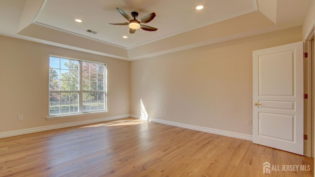 unfurnished room featuring a raised ceiling and crown molding