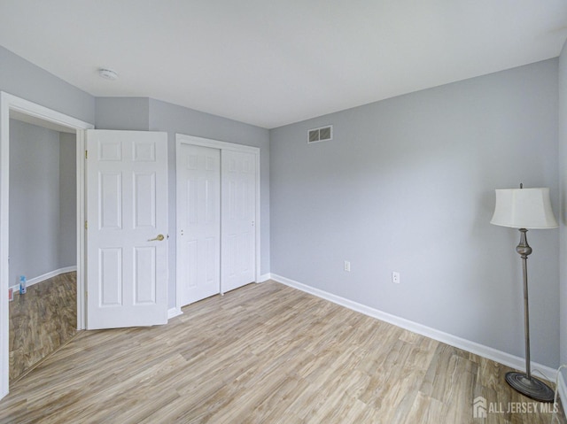 221 Morning Glory Dr, Monroe, NJ 08831 - unfurnished bedroom with light wood-style flooring, baseboards, and a closet