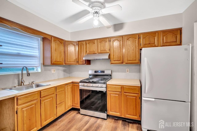 402 N Cranbury Rd Unit 8, East Brunswick, NJ 08816 - kitchen featuring freestanding refrigerator, stainless steel gas stove, under cabinet range hood, a ceiling fan, and light countertops