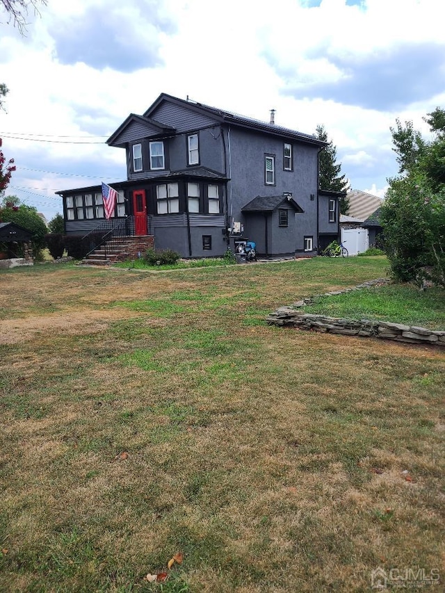 rear view of property featuring a lawn