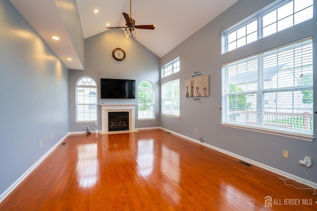4 Bernadette Cir S, Brunswick, NJ 08852 - unfurnished living room featuring ceiling fan, high vaulted ceiling, healthy amount of natural light, a fireplace with flush hearth, and hardwood / wood-style floors