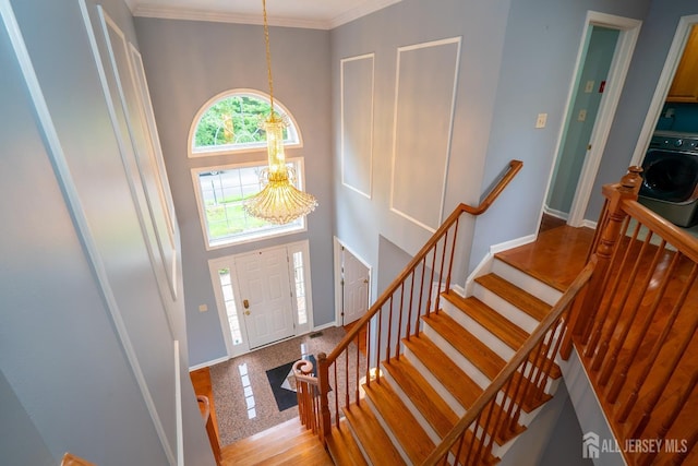 4 Bernadette Cir S, Brunswick, NJ 08852 - foyer entrance featuring washer / dryer, a chandelier, baseboards, a towering ceiling, and ornamental molding