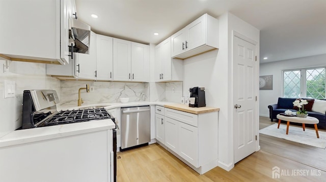 13 Prospect St, Metuchen, NJ 08840 - kitchen with stainless steel appliances, light wood-style floors, decorative backsplash, a sink, and recessed lighting
