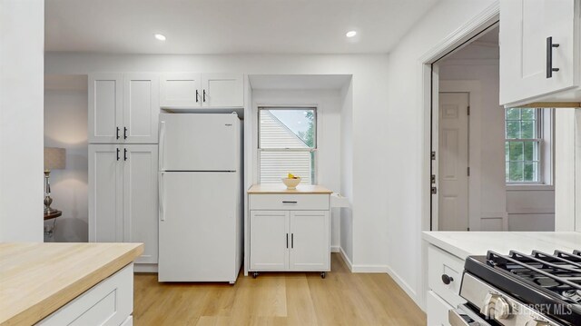 13 Prospect St, Metuchen, NJ 08840 - kitchen with freestanding refrigerator, light wood-style floors, plenty of natural light, white cabinets, and recessed lighting