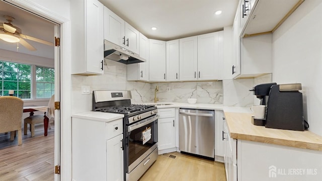 13 Prospect St, Metuchen, NJ 08840 - kitchen featuring appliances with stainless steel finishes, under cabinet range hood, light wood finished floors, backsplash, and recessed lighting