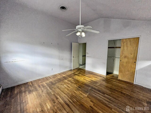 unfurnished bedroom featuring dark wood-type flooring, vaulted ceiling, and ceiling fan