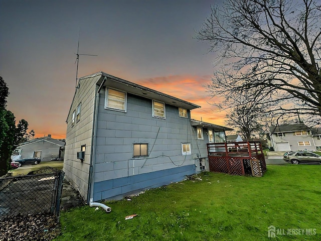 exterior space featuring a lawn, a deck, and fence