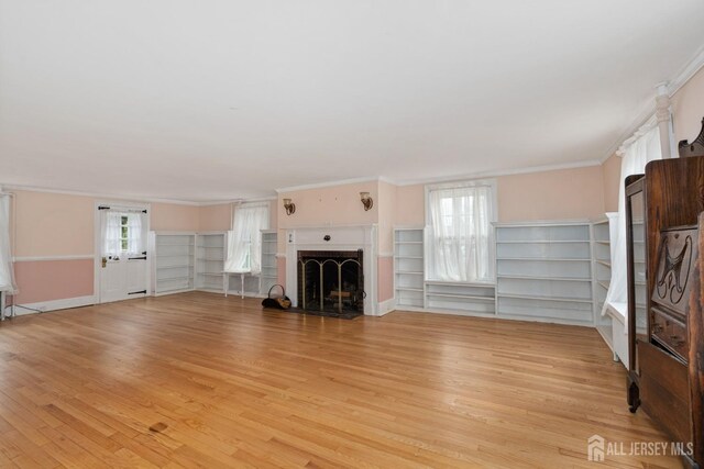 unfurnished living room with light hardwood / wood-style floors and ornamental molding