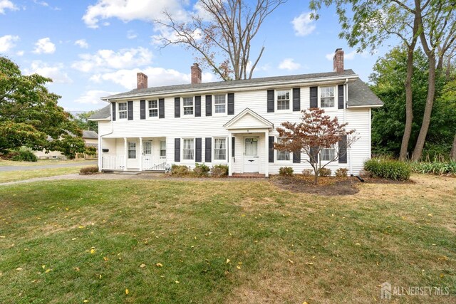 colonial home featuring a front lawn