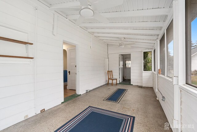 unfurnished sunroom with vaulted ceiling with beams and ceiling fan