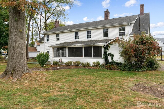 view of front facade featuring a sunroom and a front lawn