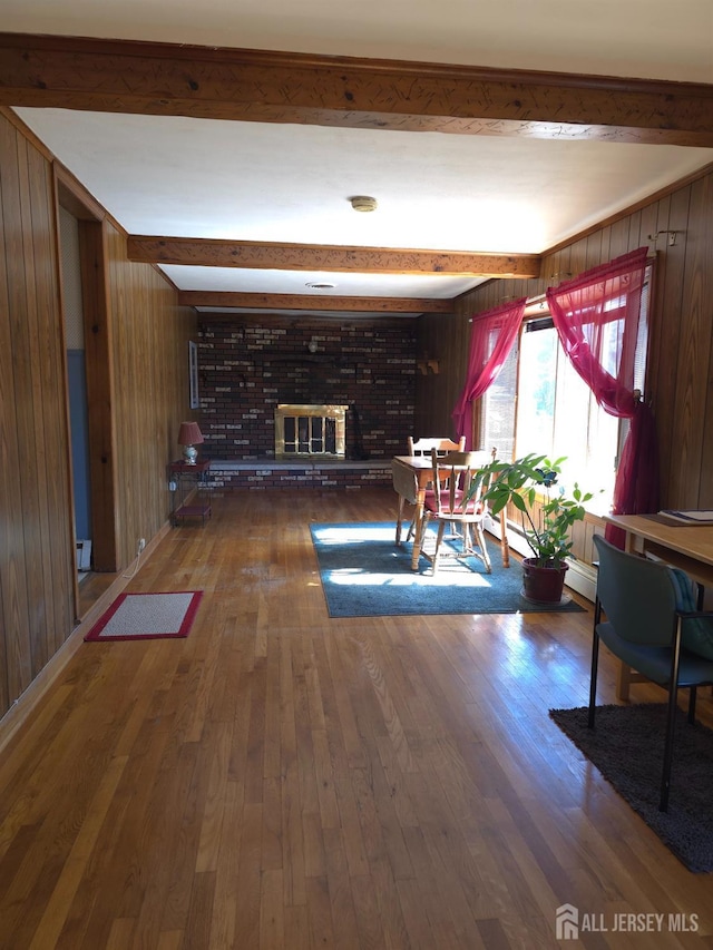 144 Buckelew Ave, Jamesburg, NJ 08831 - living room featuring wood walls, wood finished floors, a fireplace, and beamed ceiling
