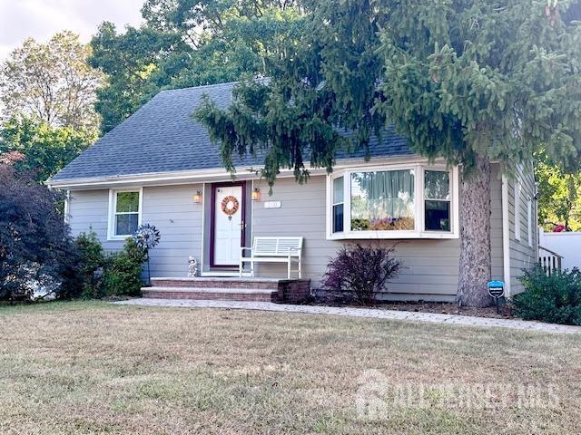 view of front of house with a front yard and a shingled roof