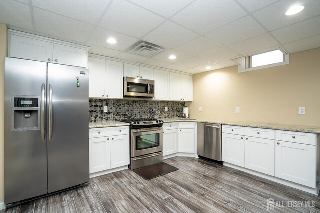45 Green Ash St, Monroe, NJ 08831 - kitchen with stainless steel appliances, white cabinetry, dark wood finished floors, backsplash, and a drop ceiling
