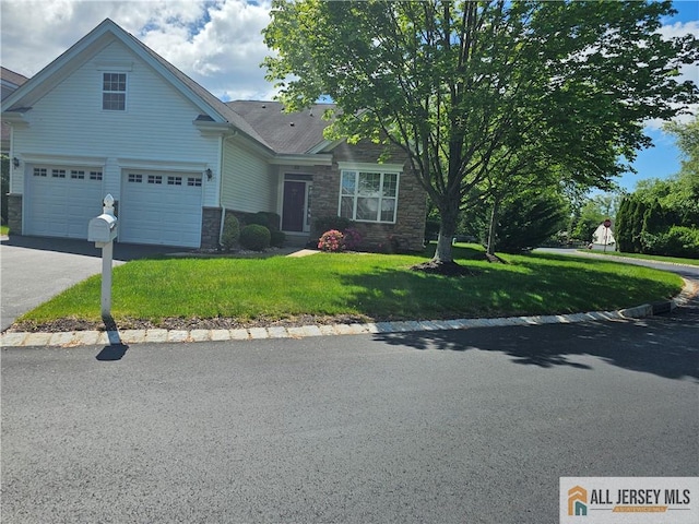 view of front of home featuring stone siding, a front yard, and driveway