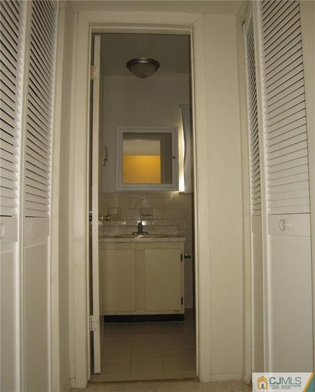 corridor featuring tile patterned flooring and sink