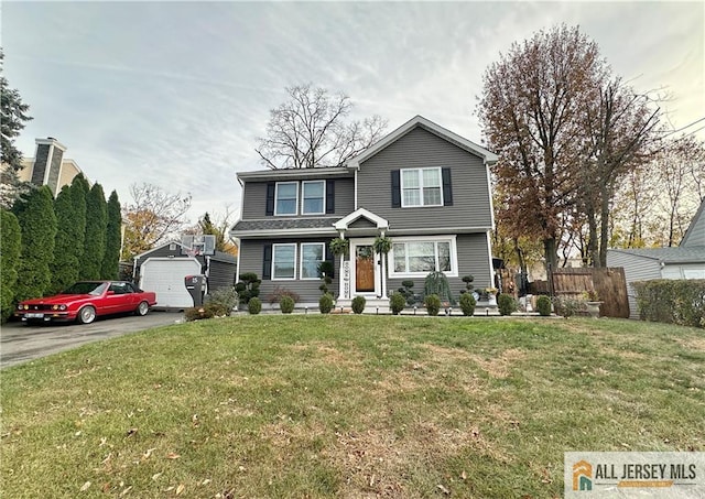 view of front of property featuring a front yard, a garage, and an outdoor structure