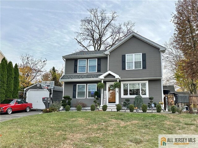 view of front facade featuring a garage, an outdoor structure, and a front lawn