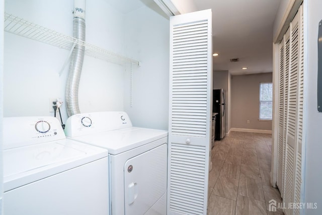 laundry area with washing machine and dryer, laundry area, visible vents, and baseboards