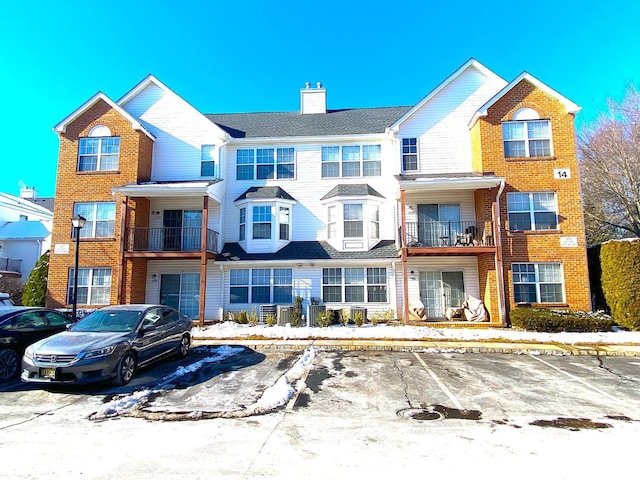 view of front of home featuring uncovered parking and a chimney