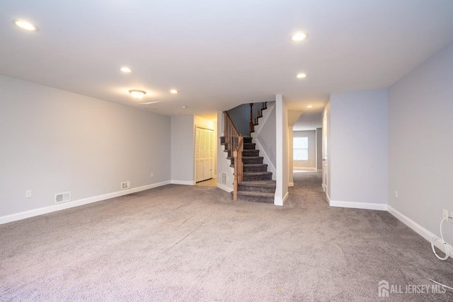 below grade area with carpet floors, recessed lighting, visible vents, baseboards, and stairs